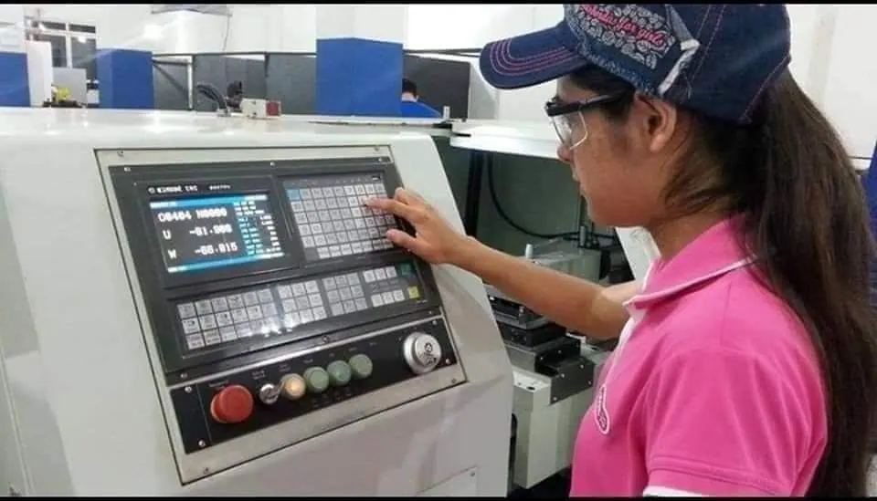 Aluna programando o comando de uma máquina CNC