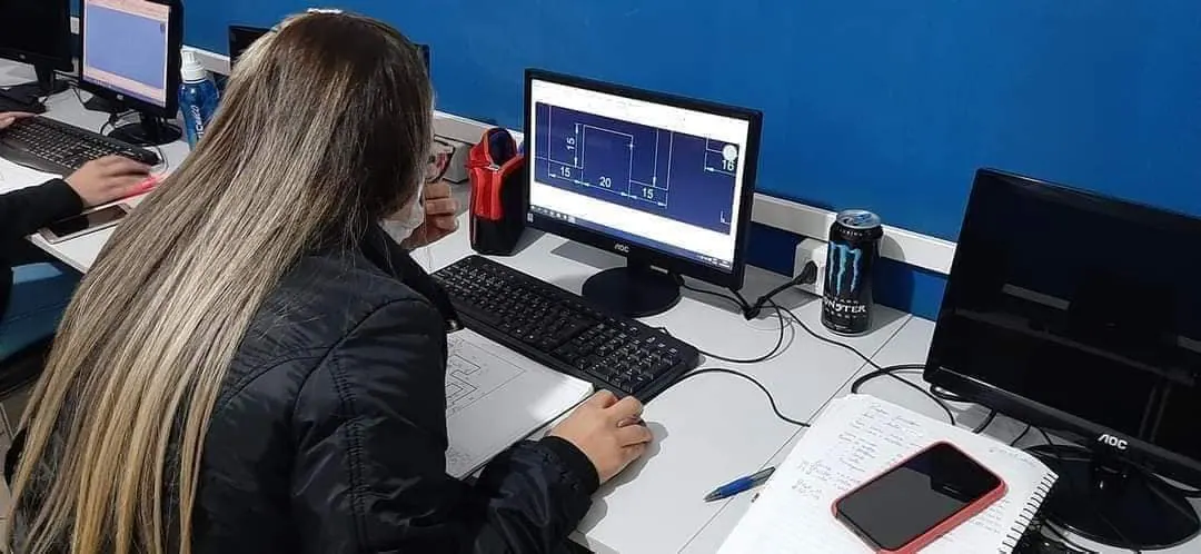 Aluna desenhando peça em software CAD